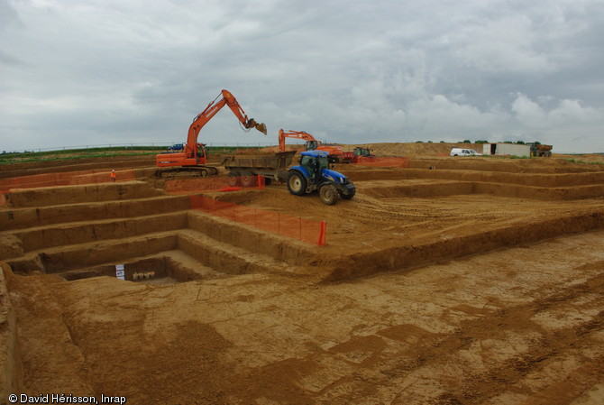 Décapage à la pelle mécanique afin d'atteindre le niveau acheuléen, daté d'au moins 300 000 ans, Étricourt-Manancourt (Somme), 2012.  Ce niveau est le plus ancien et le plus riche du site. Il a livré jusqu’à présent plusieurs centaines de silex taillés, dont de nombreux bifaces, outils caractéristiques de la période.