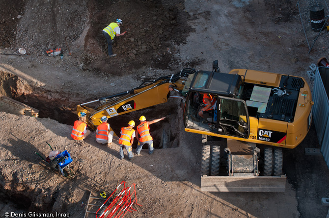 Terrassement en cours d'une tranch&eacute;e de 5 m de profondeur sous la surveillance des arch&eacute;ologues, place du Ch&acirc;teau &agrave; Strasbourg (Bas-Rhin), 2012.  
