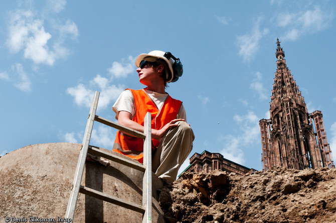 Clich&eacute; pris depuis le fond d'une tranch&eacute;e profonde de 5 m avec &agrave; l'arri&egrave;re-plan la fl&egrave;che de la cath&eacute;drale de Strasbourg (Bas-Rhin), 2012.  L'op&eacute;ration men&eacute;e place du Ch&acirc;teau s'ins&egrave;re dans le cadre du r&eacute;am&eacute;nagement du site par la ville et la communaut&eacute; urbaine. 