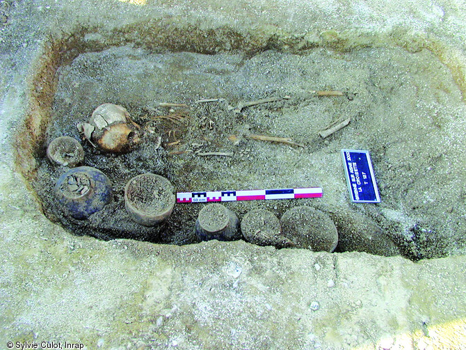 Enfant décédé vers 7 ans, accompagné de vases aux dimensions plus réduites que ceux accompagnant les adultes de la nécropole, second âge du Fer, Brienne-sur-Aisne (Ardennes), 2003.  Le choix dans la sélection des vases est vraisemblablement lié à la jeunesse du défunt.   Photo publiée dans l'ouvrage Archéologie de la mort en France, Lola Bonnabel, coll. Archéologies de la France. 