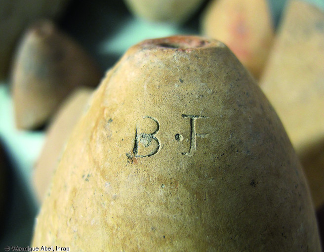 Forme à sucre du XIXe s. mise au jour par la fouille du tunnel de la Joliette à Marseille en 1995.  Cette céramique en forme d'obus, poinçonnée du monogramme  B.F.  (ou  B.R.  incomplet), est un des rares objets de raffinage du sucre à Marseille.   Photo publiée dans le numéro 31 de la revue de l'Inrap Archéopag