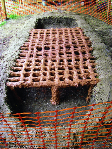 Reconstitution exp&eacute;rimentale du fourneau &agrave; sel de Pont-R&eacute;my (Somme) r&eacute;alis&eacute;e &agrave; l'&eacute;chelle 1 dans le parc arch&eacute;ologique de Samara (Somme) en 2007.  En un cycle, le fourneau pouvait produire entre 250 et 350 kg de sel sous forme de pains compacts pesant entre 1 et 2,5 kg.   Photo publi&eacute;e dans le num&eacute;ro 31 de la revue de l'Inrap <a class= rte-link-ext  href= http://www.inrap.fr/archeologie-preventive/Recherche-scientifique/Archeopages/Les-numeros/31-32-33-2011/Numero-31/Dossier-Sucre-sale/p-13961-Les-ages-du-sel-en-Gaule-du-Nord.-Quelques-sites-lateno-romains-de-production-de-sel-marin