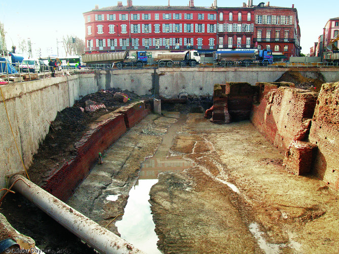 Vue générale du fossé majeur entre le rempart, à droite, et le mur de contrescarpe, à gauche, du château des comtes de Toulouse (Haute-Garonne), 2005.  Le fossé, aménagé dans la seconde moitié du XIIIe s., est large de 18 m et profond de 9 m.  Photo publiée dans le numéro 19 de la revue de l'Inrap <a class= rte-link-ext  href= http://www.inrap.fr/archeologie-preventive/Recherche-scientifique/Archeopages/Les-numeros/18-19-20-2007/Numero-19/Dossier-Signes-de-pouvoir/p-9410-Perennite-des-lieux-de-pouvoir.-Le-chateau-Narbonnais-de-Toulouse-porte-monumentale-antique-transf