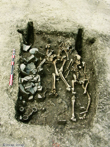 Tombe à char du IVe s. avant notre ère à Reims  la Neuvillette  (Marne), 2001.Un homme est enterré sur un char avec ses armes, une épée et deux fers de lance. Placé simultanément ou peu après, un jeune adulte est déposé dans une fosse surcreusée au fond de la tombe monumentale. Un troisième individu sera inhumé dans le comblement supérieur de cette dernière avec son propre mobilier.     Photo publiée dans le numéro 19 de la revue de l'Inrap <a class= rte-link-ext  href= http://www.inrap.fr/archeologie-preventive/Recherche-scientifique/Archeopages/