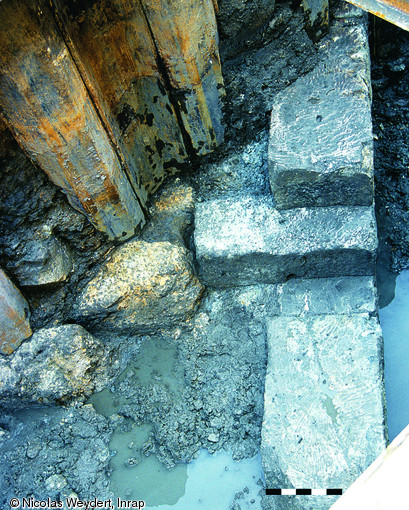 A droite&nbsp;apparaissent&nbsp;des blocs en calcaire d'&eacute;poque august&eacute;enne li&eacute;s &agrave; un am&eacute;nagement portuaire. A gauche, trois blocs de travertin mis en place vers le milieu du IVe&nbsp;s. avant notre &egrave;re, appartenant &agrave; un m&ocirc;le qui prot&eacute;geait le port de la cit&eacute; grecque.Ces structures ont &eacute;t&eacute; d&eacute;couvertes &agrave; l'occasion d'une surveillance arch&eacute;ologique de travaux d'am&eacute;nagement men&eacute;s rue de la R&eacute;publique &agrave; Marseille.&nbsp;  Photo publi&eacute;e dans le num&eacute;ro 19 de la revue de l'Inrap <a class= rte-link-ext  href= http://www.inrap.fr/archeologie-preventive/Recherche-scient