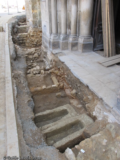 S&eacute;pultures en sarcophages et coffrages ma&ccedil;onn&eacute;s d&eacute;couvertes devant le portail de l'&eacute;glise Saint-M&eacute;dard &agrave; Thouars (Deux-S&egrave;vres) en 2011. A l'arri&egrave;re-plan, dans la tranch&eacute;e, apparaissent les caves d'&eacute;choppes construites au XVIe&nbsp;s. de part et d'autre du portail.