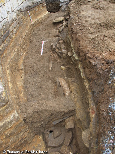 S&eacute;pultures en coffrages et niveaux de circulation au nord de l'&eacute;glise Saint-M&eacute;dard de Thouars (Deux-S&egrave;vres), 2011.La mise en &oelig;uvre de ces niveaux successifs montre que l'espace fun&eacute;raire &eacute;tait pleinement int&eacute;gr&eacute; au tissu urbain.&nbsp;
