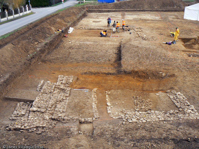 Vue d'ensemble de bâtiments des XIIIe et XIVe s. en cours de fouille, Moult (Calvados), 2013.Les deux édifices encadrent une grande cour centrale empierrée. 