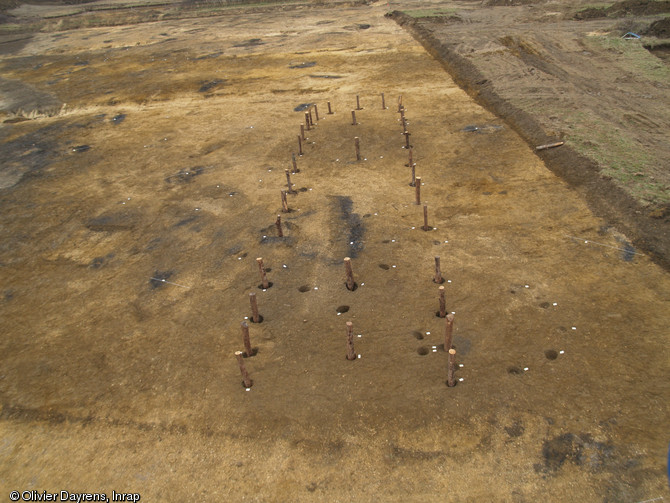 Reconstitution in situ des fondations d'une maison du N&eacute;olithique r&eacute;cent, 3500-3000 avant notre &egrave;re, Bergerac (Dordogne), 2007.  Les quatre poteaux &agrave; l'int&eacute;rieur de la maison supportaient un toit &agrave; double pente r&eacute;alis&eacute; en mat&eacute;riaux v&eacute;g&eacute;taux. 