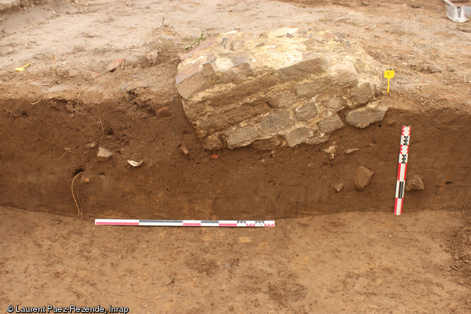 Base de pilier évoquant l'un des ultimes aménagements de ce quartier de la ville antique, IIIe s. de notre ère, Portbail (Manche), 2012.Il s'agit d'un morceau de maçonnerie arraché à son mur d'origine pour être remployé comme fondation de pilier afin d'étayer des bâtiments en cours de démantèlement.