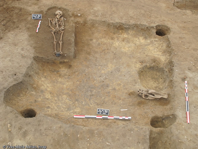 Sépulture de la fin du VIIe s. de notre ère recoupant un fond de cabane comblé au VIIe s., Val-de-Reuil (Eure), 2012.Un cimetière est aménagé à la fin du VIIe s. juste à côté d'un habitat mérovingien qui formait alors un petit hameau se développant autour de ruines antiques.