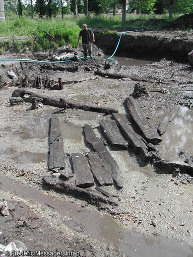 Éléments de construction réutilisés en 1018 pour la réparation du platelage d'une passerelle construite en 995 et effondrée dans le fossé d'enceinte, Pineuilh (Gironde), 2003.   