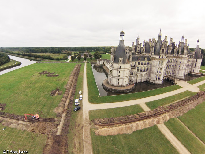 Vue générale du parterre oriental prise depuis le nord en regardant vers le sud, château de Chambord (Loir-et-Cher), 2013. Le sondage dans l’axe vertical du cliché a permis d’observer un certain nombre d’aménagements liés à la création du jardin « à la française ». Malgré la très grande quantité de terres à déplacer (de 2 à 3 m de profondeur sur 65.000 m²), les premières plantations ont été terminées en 1734, seulement quatre ans après le début des travaux.