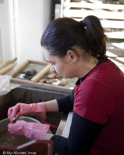 Delphine Beranger, archéologue, nettoie de la céramique, centre Inrap de Valence (Drôme), 2013.