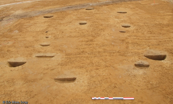 Bâtiment construit sur poteaux porteurs et présentant un plan en navette, ferme gauloise de Coulans-sur-Gée (Sarthe), 2012.Le plan en navette correspond à une charpente interne destinée à soutenir la toiture. Les murs, en torchis, devaient être sensiblement décalés vers l'extérieur, agrandissant ainsi l'espace habitable.