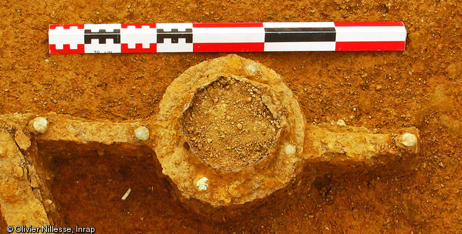 Vue de détail de l'umbo du bouclier découvert dans un dépôt d'armes de la fin du IVe - début du Ve s. de notre ère, Fontenay-sur-Vègre (Sarthe), 2012.Cette pièce de bouclier est en fer et en alliage cuivreux. Non visible sur la photo mais identifié grâce à la radiographie, le manipule se prolonge par deux barres qui se fixent sur le plat du bouclier.