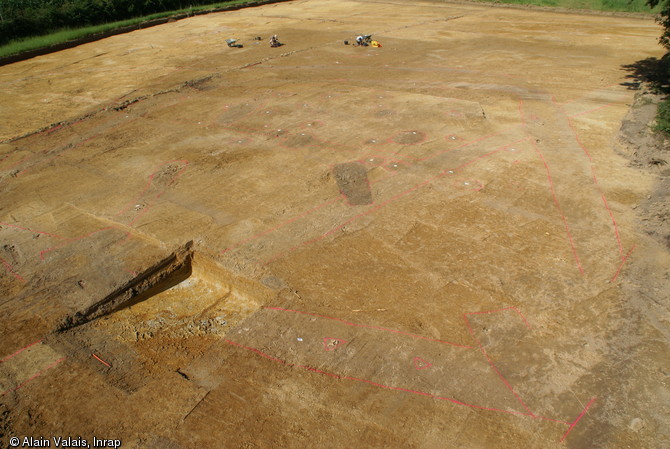 Vue générale du site des Touches à Juigné-sur-Sarthe (Sarthe), 2012.À un carrefour de chemins anciens, la fouille a révélé les vestiges d'un habitat monumental en bois des XIIIe-XIVe s. L'emplacement du fossé entourant l'enclos et les trous de poteaux sont entourés en rouge.