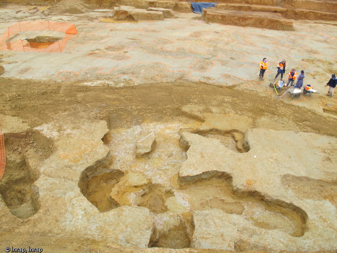 Vue du fond de la mine de fer du Bois Beslan à La Milesse (Sarthe), 2012.Au premier plan apparaît un ensemble de galeries intégralement fouillées, à l'arrière-plan la poursuite du réseau souterrain non fouillé marqué à la peinture orange.