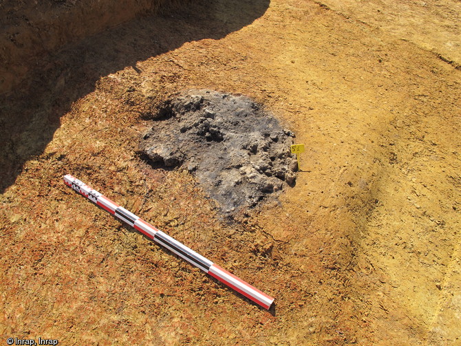 Vue de la scorie piégée à la base du four en fosse, époque gauloise, la Mare, La Milesse (Sarthe), 2012.La couronne rouge sur les parois est le résultat des très hautes températures de chauffe.