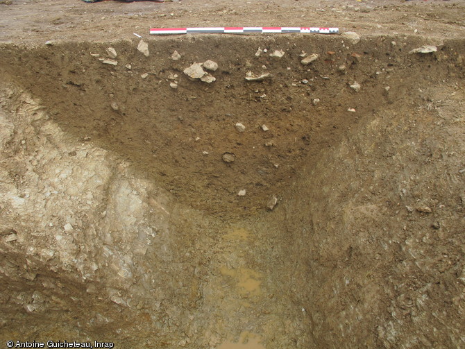 Coupe réalisée dans le premier fossé entourant le sanctuaire au Ier s. de notre ère, La Grillère, Saint-Denis-du-Maine (Mayenne), 2012.Cette enceinte fossoyée, taillée dans le schiste, forme un carré de 54 m de côté.