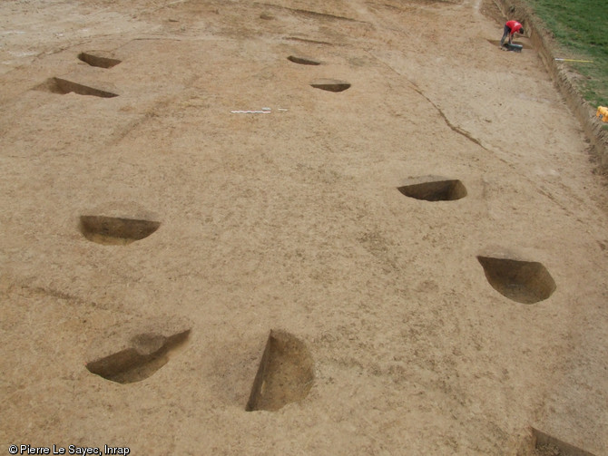B&acirc;timent du Xe&nbsp;s. dont le plan est dessin&eacute; au sol par des trous de poteaux, La Grande Ma&ccedil;onnais, Torc&eacute; (Ille-et-Vilaine), 2013.Un habitat des Xe-XIe&nbsp;s., mat&eacute;rialis&eacute; par quatre b&acirc;timents construits sur poteaux, constitue les vestiges les plus remarquables du site.