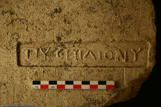 Vue de d&eacute;tail d'une tuile d&eacute;couverte dans le complexe thermal romain de la rue Trinquet &agrave; Marseille, 2007.Elle porte une inscription en grec, vraisemblablement &agrave; caract&egrave;re fiscal, qui mentionne en abr&eacute;g&eacute; le nom du fabricant et celui du magistrat.    Photo publi&eacute;e dans l'ouvrage Quand les arch&eacute;ologues red&eacute;couvrent Marseille, M. Bouiron, P. Mellinand.