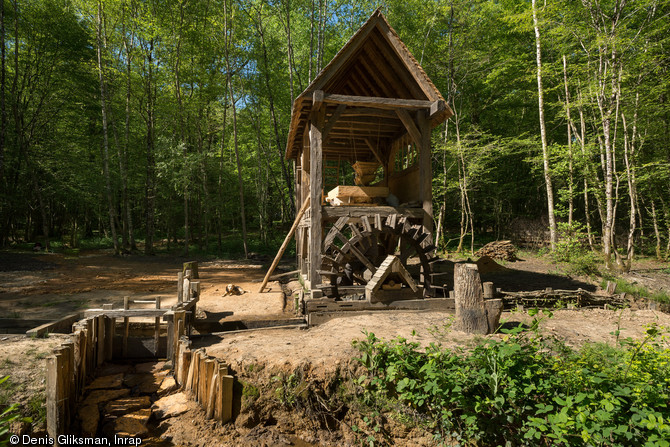 Le moulin avec la roue hydraulique et une vanne permettant la décharge du bief directement en amont du coursier de la roue, Guédelon (Yonne), 2014.La confrontation de la théorie, des hypothèses issues des fouilles et de la réalité de la construction, permet d’approcher au plus près le savoir-faire des artisans médiévaux.