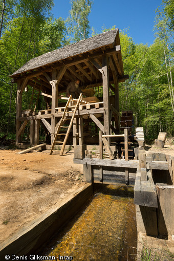 Le moulin vu de l'est avec au premier plan le bief en activité, Guédelon (Yonne), 2014.Le moulin, qui produira de la farine pour les besoins du fournil du château de Guédelon, est établi sur un ruisseau.