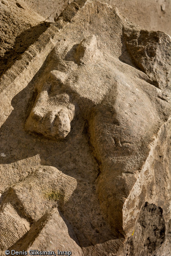 Vue de détail d'un cheval posant le sabot sur un vase, registre supérieur de l'attique de la façade monumentale du sanctuaire de Pont-Sainte-Maxence, IIe s. de notre ère, 2014.