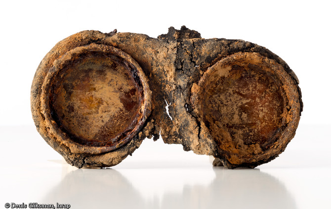 Fragment de masque &agrave; gaz du type  General Service Light Respirator , (introduit &agrave; partir de 1943 dans les unit&eacute;s d'infanterie britanniques et canadiennes) en caoutchouc moul&eacute; et qui conserve ses deux oculaires de protection, cercl&eacute;s de m&eacute;tal (L. 18,5 cm). Datant de l'op&eacute;ration Spring (offensive du 25 juillet 1944) et d&eacute;couvert dans une fosse &agrave; Bourgu&eacute;bus (Calvados), 2013.