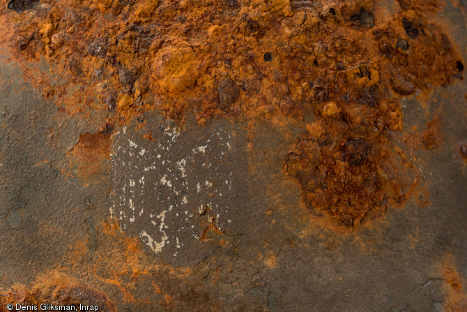 D&eacute;tail de l'&eacute;cusson : d&eacute;calcomanie d'un aigle aux ailes abaiss&eacute;es et tenant dans ses serres une croix gamm&eacute;e, ce qui identifie un casque attribu&eacute; &agrave; un soldat de l'arm&eacute;e de terre (Heer) allemande. Datant de la Bataille de Normandie (&eacute;t&eacute; 1944) et d&eacute;couvert &agrave; Troarn (Calvados), 2009. 