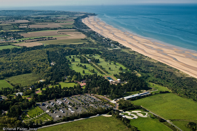 Vue a&eacute;rienne d'Omaha Beach, ici entre Colleville-sur-Mer et Saint-Laurent-sur-Mer (Calvados), l'une des cinq plages du d&eacute;barquement de Normandie. Les troupes am&eacute;ricaines y d&eacute;barqu&egrave;rent au matin du 6 juin 1944 et y subirent les plus lourdes pertes (4000 morts), en raison d'une mer agit&eacute;e qui enp&ecirc;cha la sortie des blind&eacute;s, un secteur difficile d'acc&egrave;s, et une forte r&eacute;sistance allemande. Elle re&ccedil;u le nom de code Omaha (ville du Nebraska) par les Am&eacute;ricains et le surnom de  Bloody Omaha  (Omaha la sanglante).