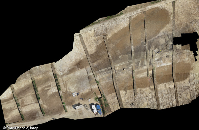 Orthophotographie du monument funéraire 29 en début de fouille de la nécropole du Néolithique moyen à Fleury-sur-Orne (Calvados), 2014.  Le tertre est enserré entre deux puissants fossés s'élargissant vers l'est. Ce monument passe de 15 m de largeur à son extrémité occidentale à 60 m à son extrémité orientale. 