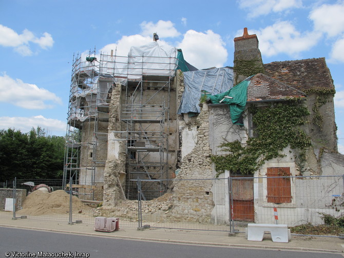 Vue au premier plan du mur d'enceinte en arraché avec son retour à angle droit du début du XVe siècle, dégagé après démolition des constructions du XIXe siècle. Au second plan, vue des encastrements des marches de l'escalier du prieuré, XVIe siècle. A gauche la tourelle d'enceinte, début XVe siècle. Abbaye Saint-Pierre à Méobecq (Indre), 2013. 