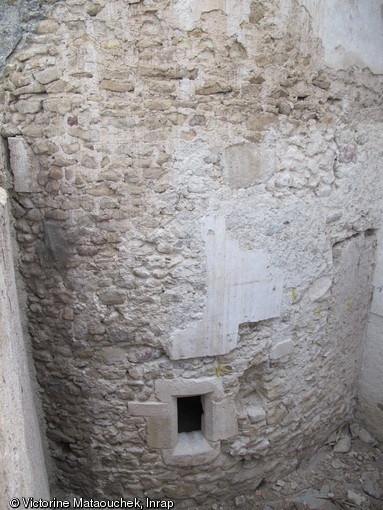 Vue d'une des tours de défense de l'enceinte de la basse-cour de l'abbaye Saint-Pierre à Méobecq (Indre), début du XVe siècle, incorporée dans des constructions du XIXe siècle et avant son dégagement, 2012.