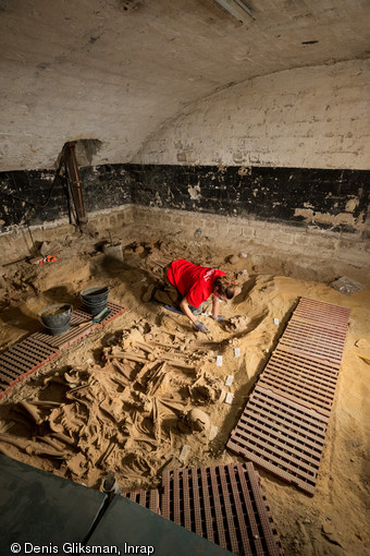 Fouille d'une fosse commune comprenant plus de 150 individus, mise au jour dans la cave d'un supermarché à Paris, en 2015.  Ont été découvertes neuf sépultures collectives appartenant à l'ancien hôpital de la Trinité, une institution construite au début du XIIIe siècle. 